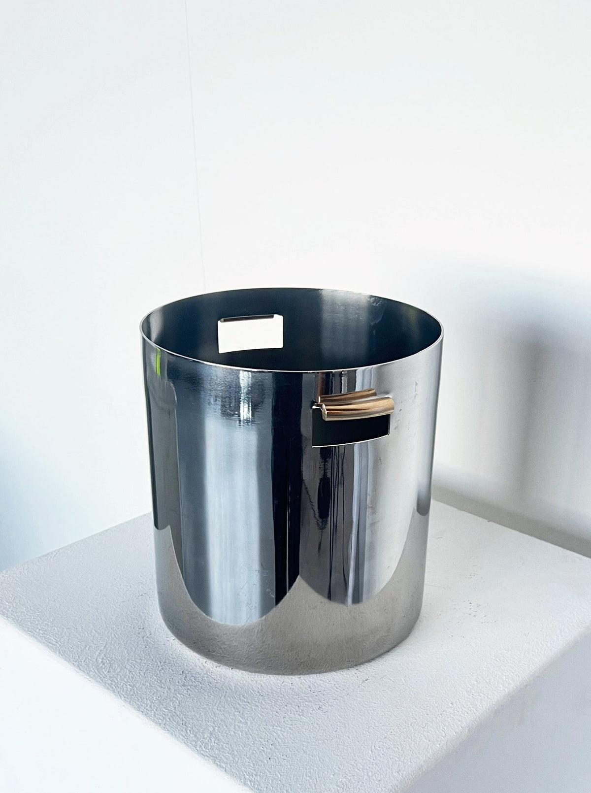 Contemporary ice bucket with brutalist aesthetic and brass handle detail