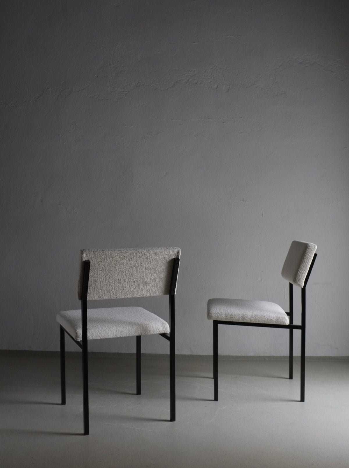 Vintage 1960s white boucle chairs with sleek black metal frames