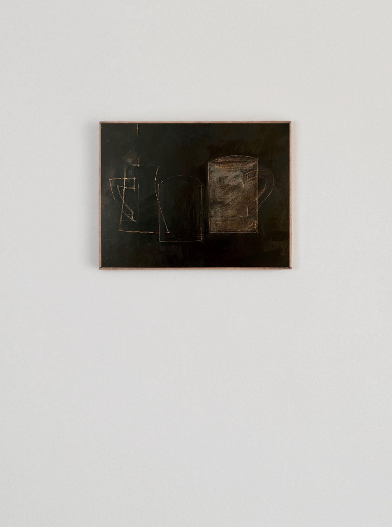 Lara Voce's "Dark Mornings" is a small, dark artwork on a white wall, showcasing abstract outlines of containers in copper or brown. The minimalist setting highlights its sculptural quality, making it the perfect complement to handcrafted or collectible furniture.