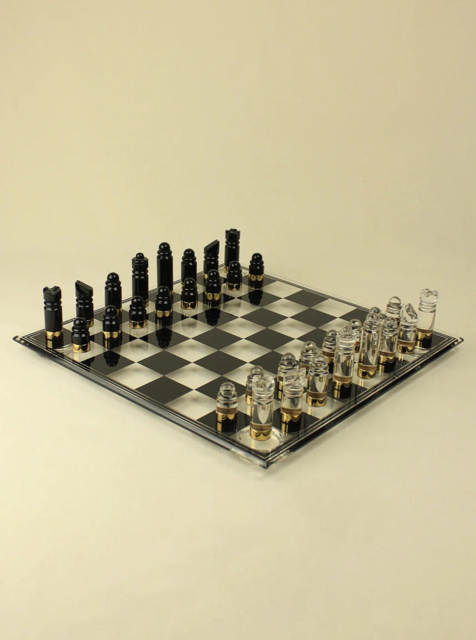 An Boga Avante Shop acrylic Chess & Checker Board set on a beige background, featuring clear and frosted pieces arranged for the beginning of a game.