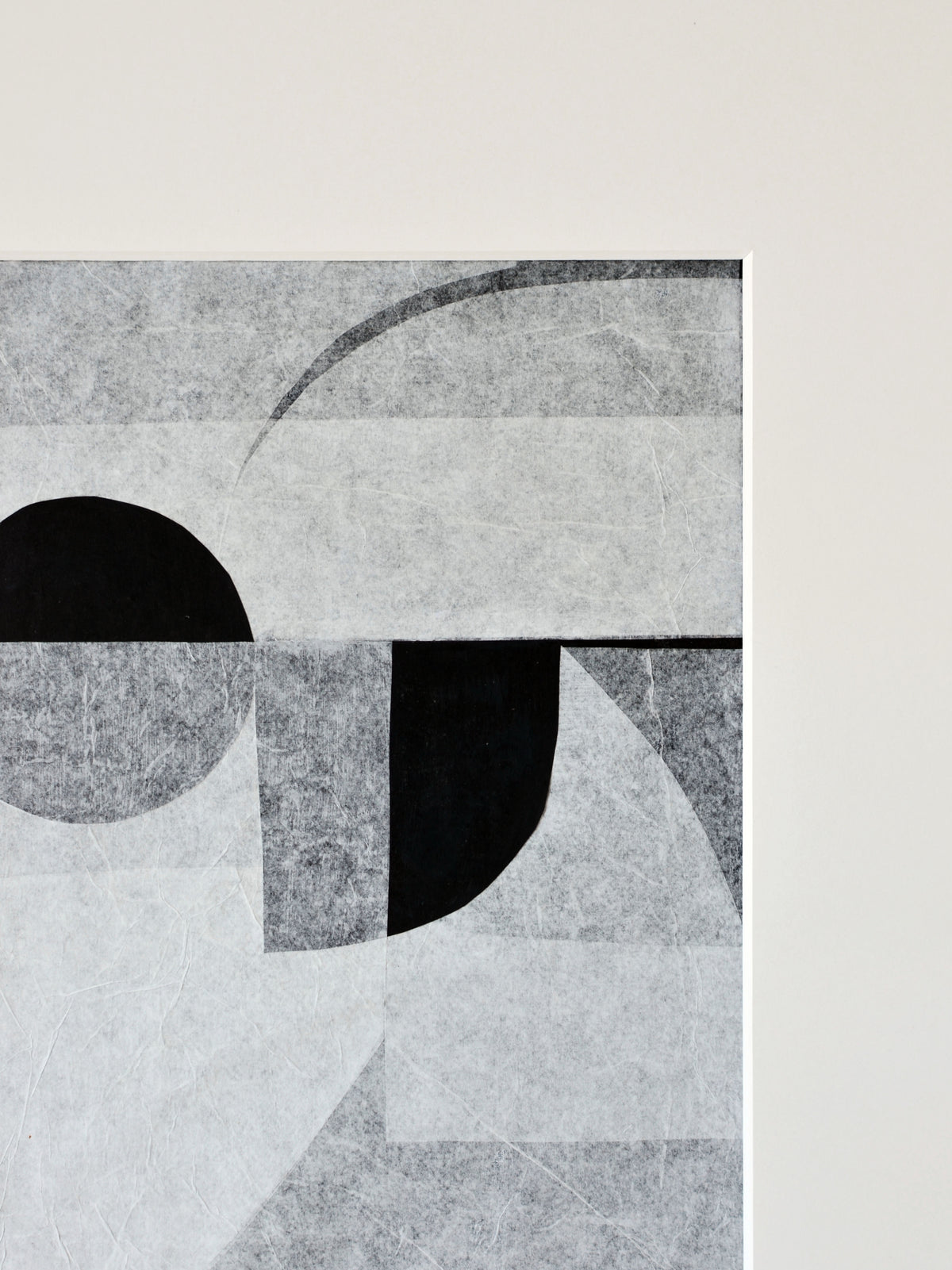 Abstract geometric artwork with overlapping shapes in shades of black, gray, and white, featuring circles and angular forms on handmade cotton paper against a cream background by Julita Elbe's Invisible.