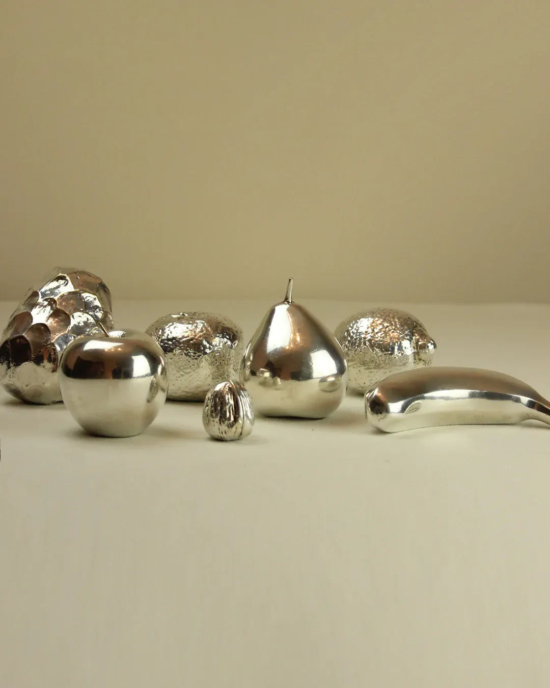  Polished silver apple statue with a sleek and modern aesthetic