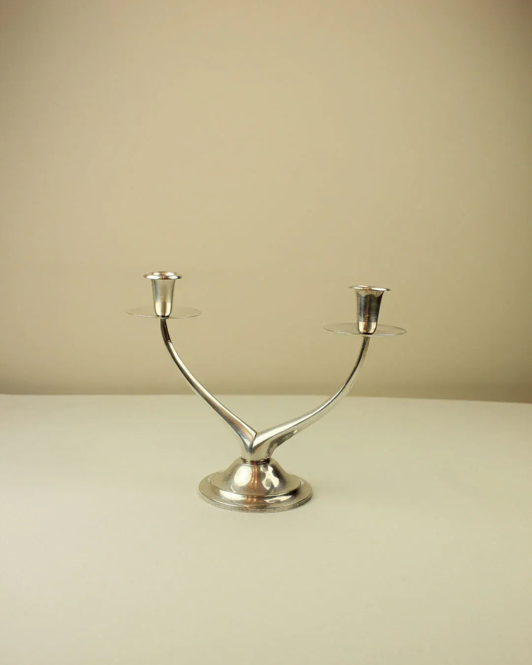  Minimalist wishbone candleholder in gold tone with tealight candle on wooden table