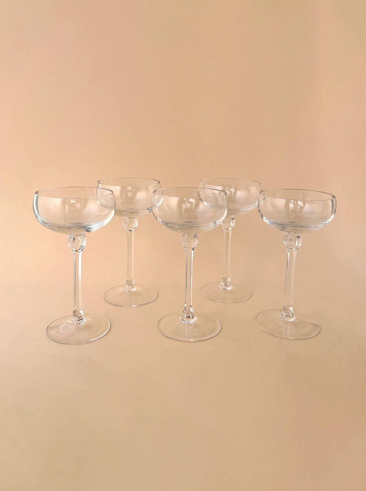 Set of 5 small champagne bowls made of clear glass with delicate rims and elegant design, perfect for serving beverages at special occasions or gatherings