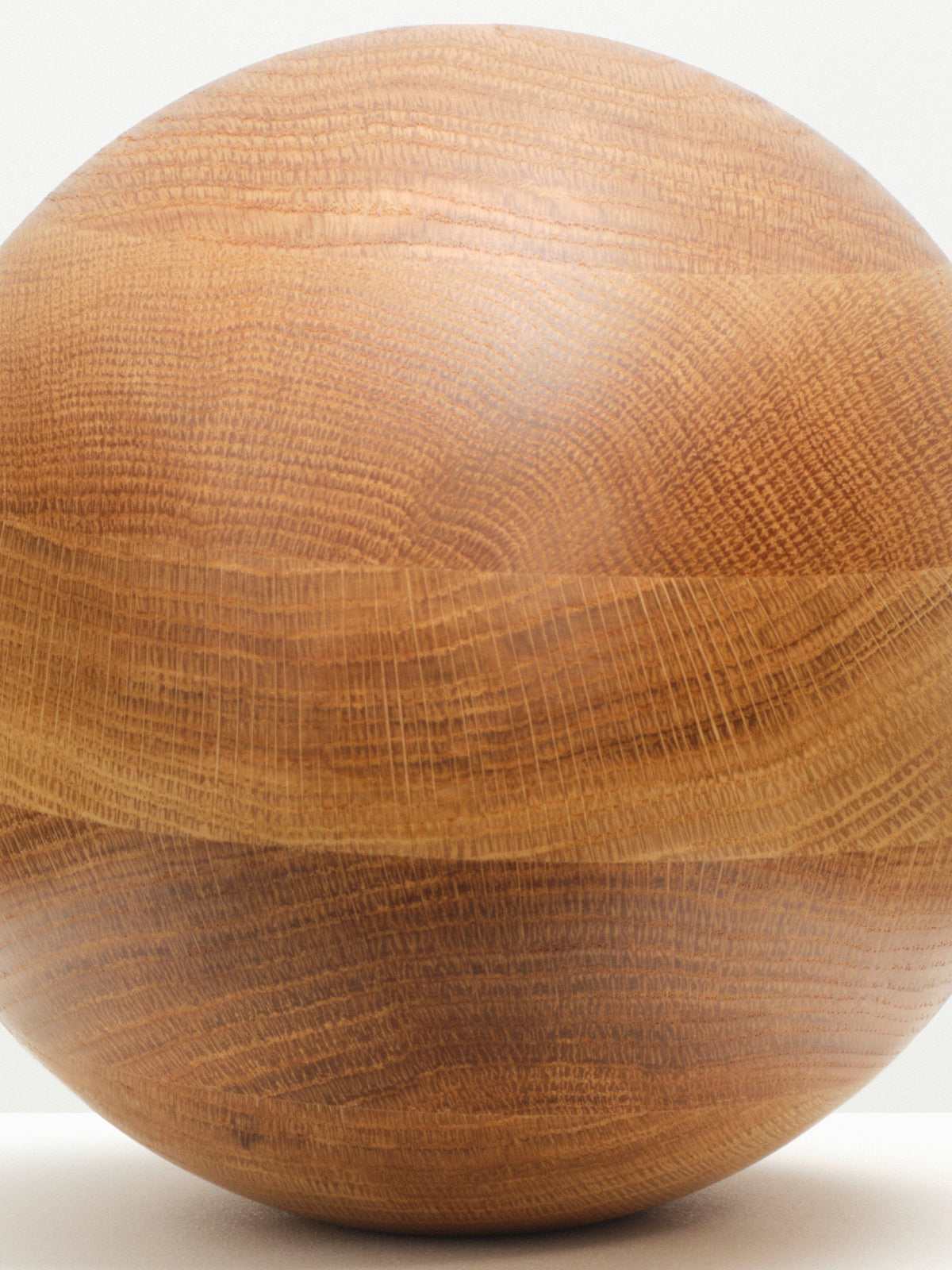Natural Oak Egg Sculpture displayed on a wooden pedestal in a natural setting