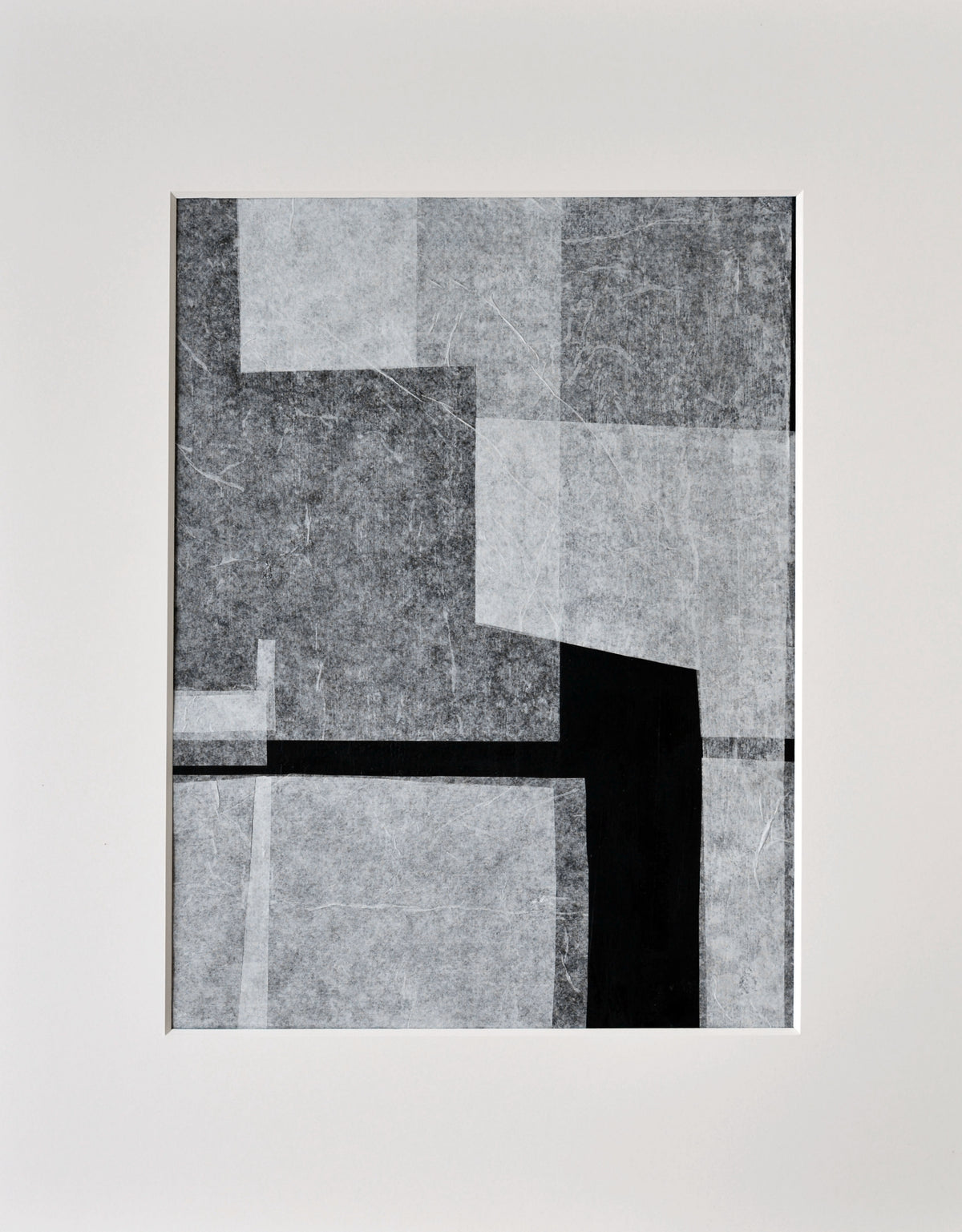 The Stone and Gap No.05/22 by Julita Elbe is a handcrafted abstract artwork featuring overlapping geometric shapes in gray and black. A bold black rectangle intersects lighter gray areas, all framed by a white border that highlights its contemporary design and minimalist style.