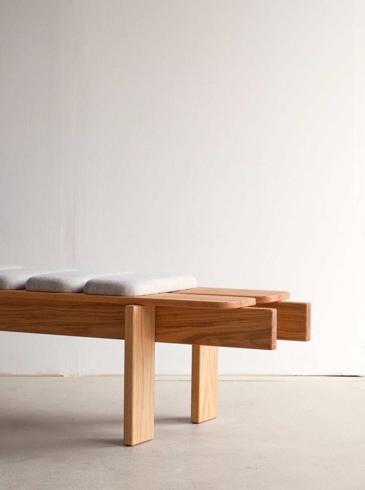  Outdoor Ueno bench placed in a lush green garden setting, perfect for relaxation